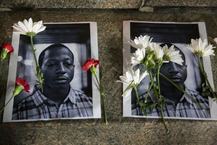 Image: Flowers rest on top of pictures of Browder in New York