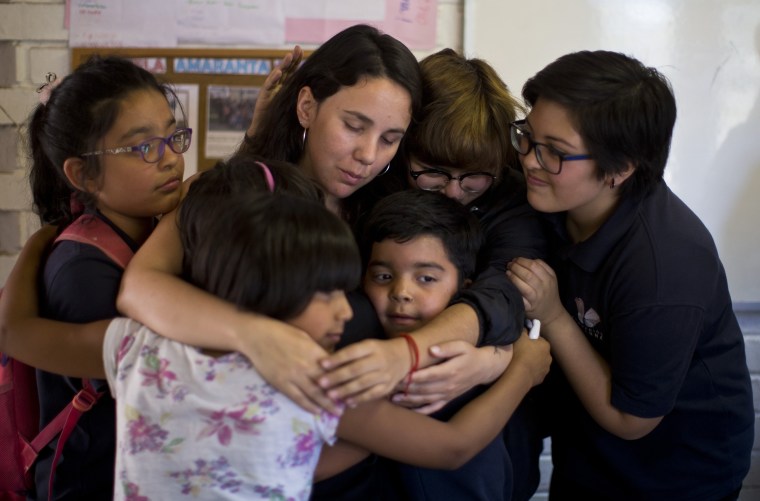 Image: Children embrace their teacher, Teani Cortes, on the last day of school at the Amaranta Gomez school in Santiago, Chile, on Dec. 12, 2018.