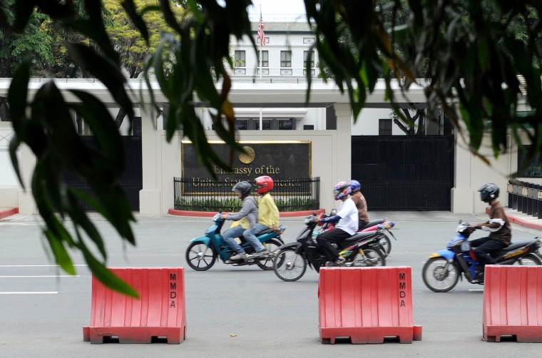 Image: Commuters pass the United States Embassy in Manila on July 6, 2013.