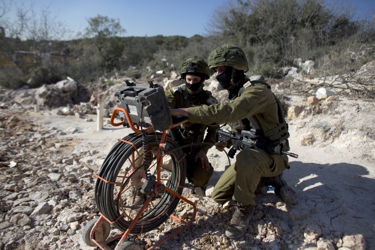 Image: Soldiers drop a camera down through a pipe into what Israeli officials called an attack tunnel