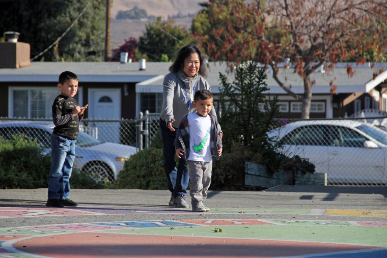Chari Plumeri, director of the Kidango-Ryan center, plays with children outside on a recent morning.
