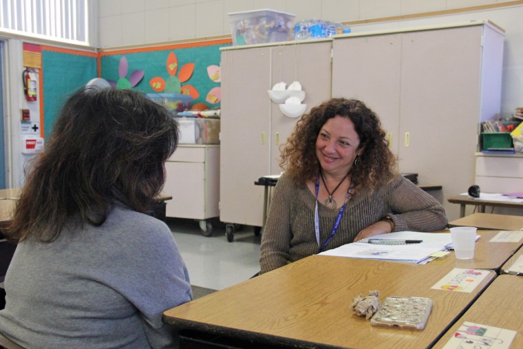 Chally Grundwag, a mental health consultant, talks to director Chari Plumeri in an empty classroom at the latter's child care center.