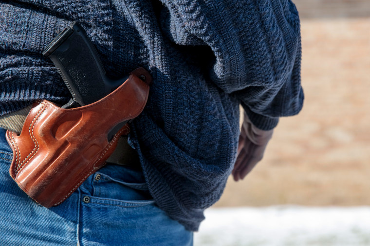 Chris Crews displays his holstered HK45 USP pistol outside Ava Assembly of God. 