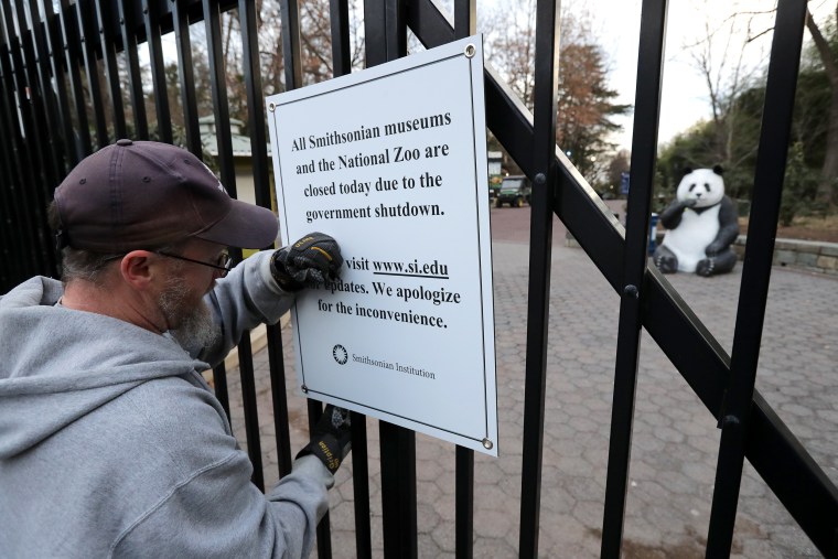 Image: A Smithsonian National Zoo employee removes a closure sign after the zoo reopened at the end of the partial government shutdown on Jan. 28, 2019.