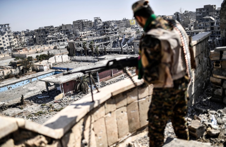 Image: A Syrian Democratic forces fighter stands guard on a rooftop after retaking the city of Raqa from ISIS fighters on Oct. 20, 2017.