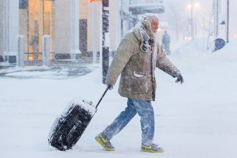 Image: A man moves luggage in snow during a winter storm in Buffalo, NY
