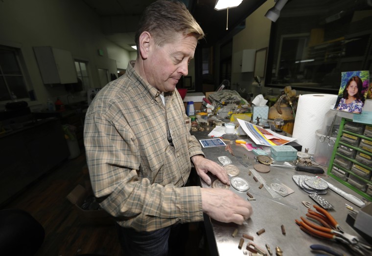 Mike Lynch, owner of Western Heritage Co., shows belt buckle designs he's been working, while talking about the effects of the government shutdown on his small business in Loveland, Colorado, on Jan. 24, 2019. Western Heritage Co. in Loveland, Colorado, which makes buckles for uniformed employees of the National Forest Service and other outdoor agencies, has seen sales plummet 85 percent this month and laid off 12 of its 13 workers.