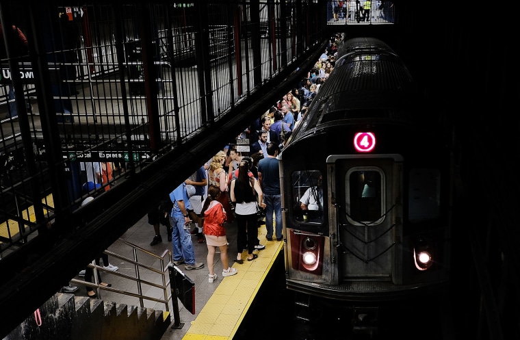 Commuters wait for the subway to arrive in New York