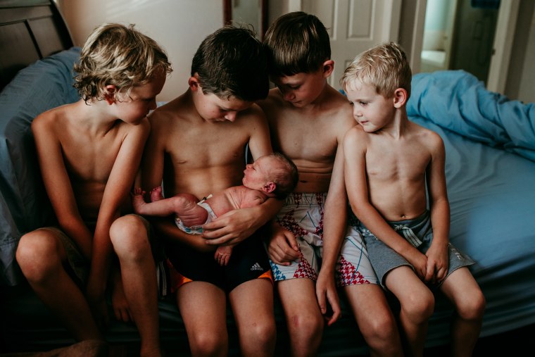 Four older brothers gaze at their new sibling in this picture of post labor calm that won third place in the postpartum category.