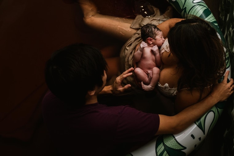 This overwhelmed mom holding her baby who is attached to a breathing tube won second place in the postpartum photography category.