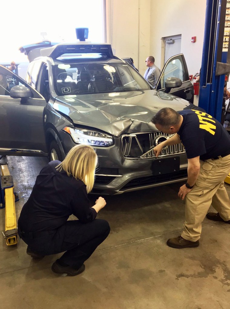 Image: Investigators examine a driverless Uber SUV that fatally struck a woman in Tempe, Ariz.