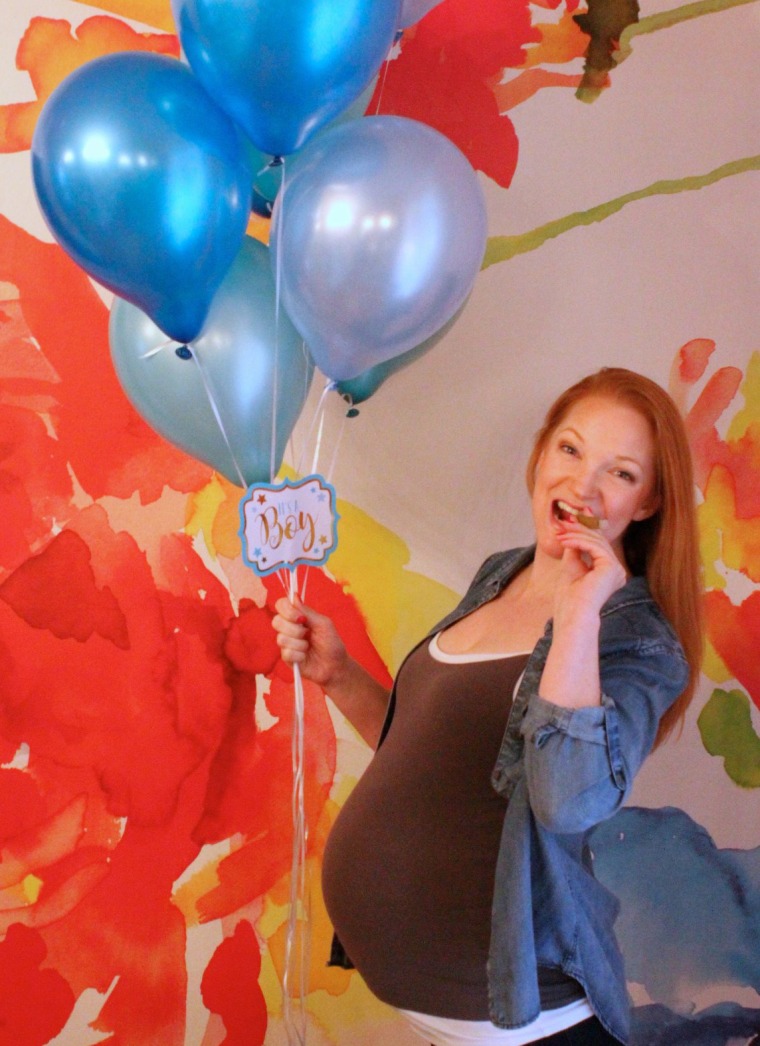 Image: Heather Lundberg Green poses with a fake baby bump to celebrate her son coming out as transgender.