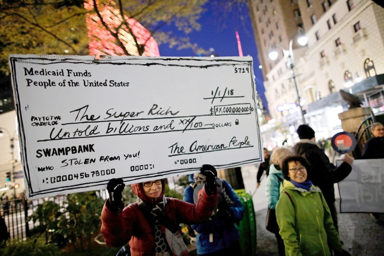 Image: Demonstrators take part in a protest against tax cuts for rich people in the Manhattan borough of New York City, New York