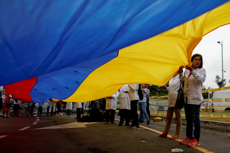 Image: Venezuelan doctors hold a flag during a protest at a blockade on a border bridge in Cucuta, Colombia, on Feb. 10, 2019.