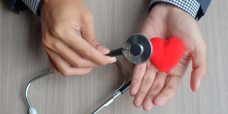 Cropped Hands Of Doctor With Heart Shape Toy