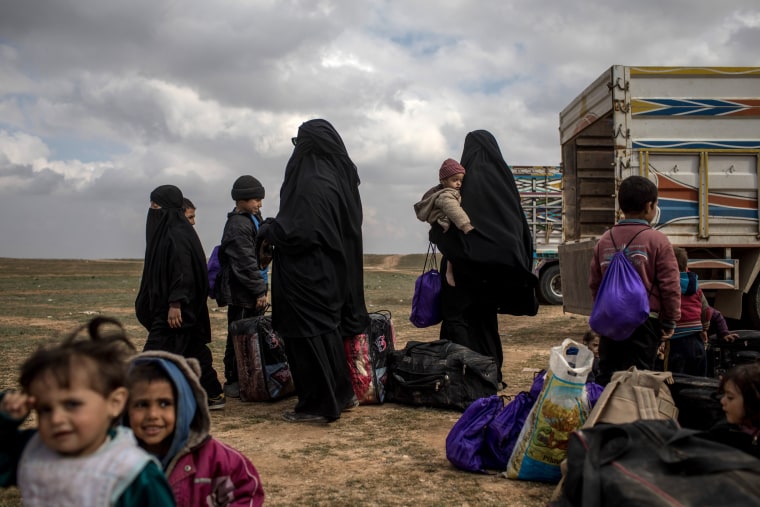 Image: Civilians wait at a makeshift checkpoint after fleeing ISIS from the Syrian city of Bagouz on Feb. 9, 2019.