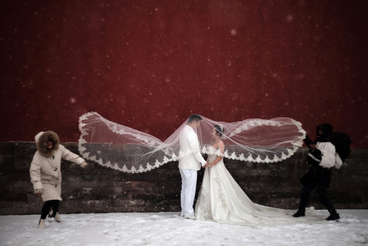 Image: Couple poses for a wedding photo shoot amid snowfall at the Imperial Ancestral Temple in Beijing