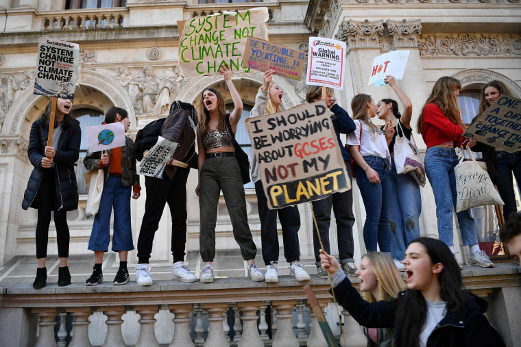 Image: Young demonstrators hold placards as they attend a climate change protest organised by "Youth Strike 4 Climate", on Whitehall in central London