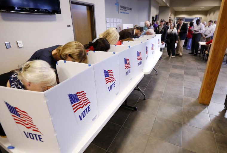 A growing line of voters, right, wait as others fill out their paper ballots in privacy voting booths on Nov. 6, 2018, in Ridgeland, Mississippi.