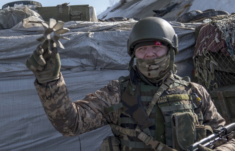 Ukrainian officer Dmitri Kebtz shows debris from artillery on what was once a main highway connecting Kiev and the Russian border