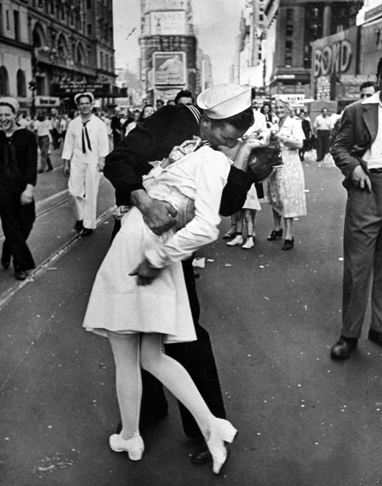 A jubilant American sailor clutching a white-unifo