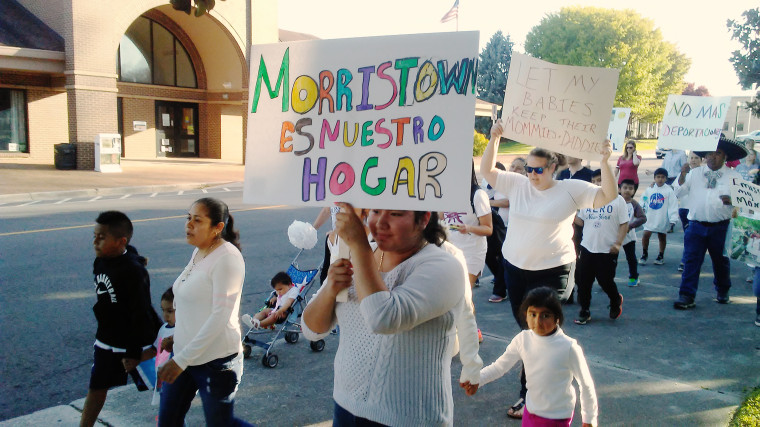 Image: Families affected by the raid and their supporters lead a procession through Morristown, Tennessee