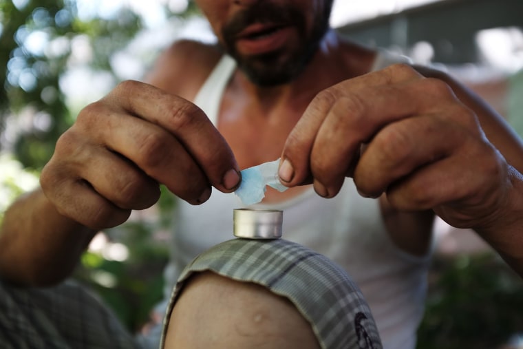 Image: Mike, a heroin addict who wants to get help, prepares to inject himself in the Kensington section of Philadelphia