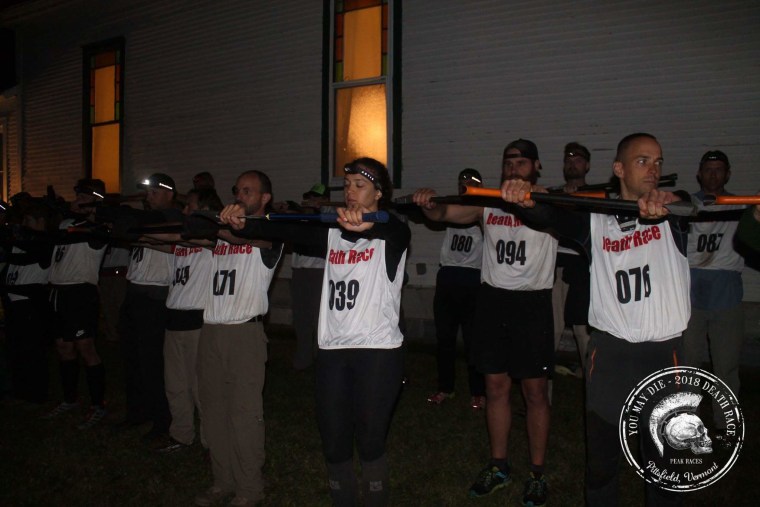 Jason Mosel, right, at a Death Race in July 2018. Participants were instructed to hold out their axes until 10 people dropped them.