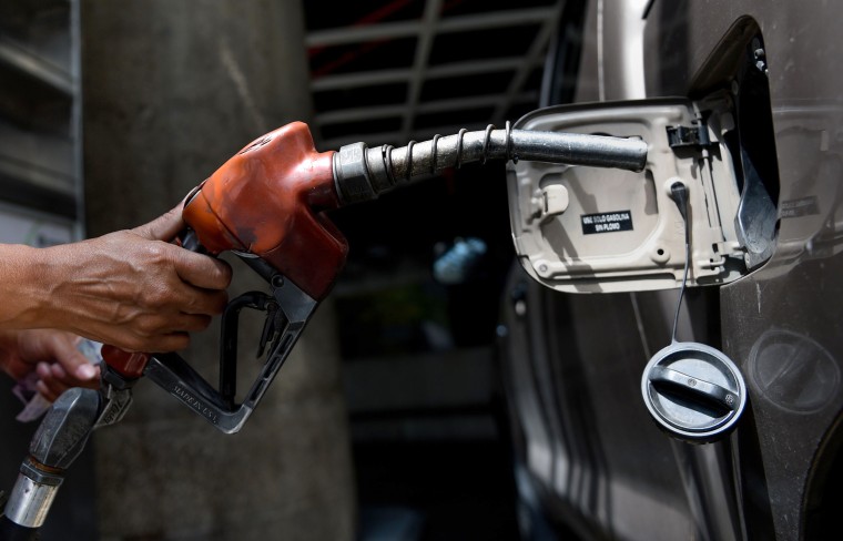 Image: An employee pumps gas into a car in Caracas, Venezuela, on Aug. 17, 2018.