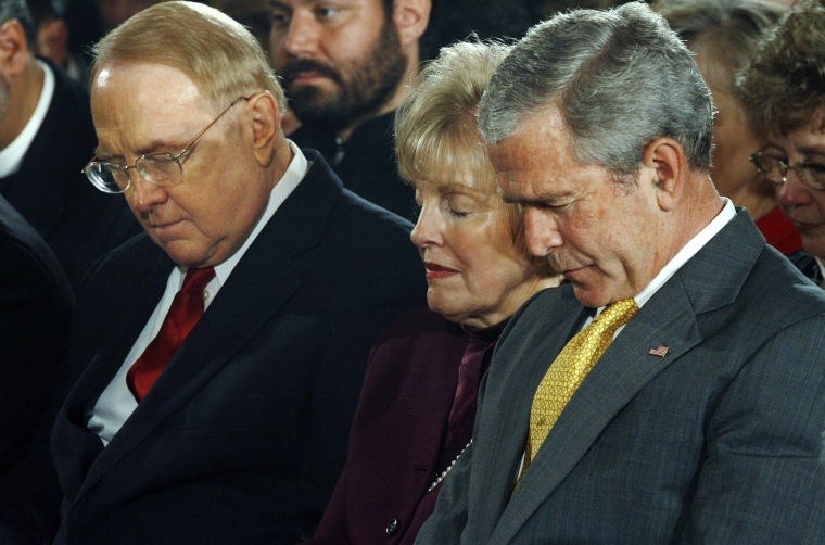Image: President George W. Bush bows his head in prayer along with Dr. James Dobson, left, during the National Day of Prayer ceremony at the White House in 2007.