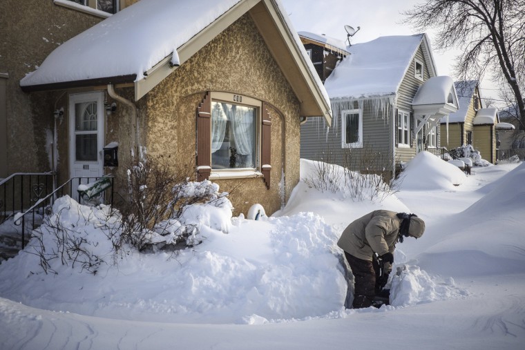 Image: Tom Sundry shovels the sidewalk in front of his house in Rochester