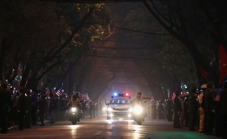 Image: Bystanders line the road as the motorcade of U.S. President Donald Trump approaches in Hanoi
