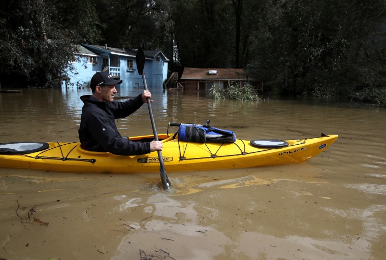 Image: A kayaker paddles through a flooded neighborhood on Feb. 27, 2019 in Forestville, California.