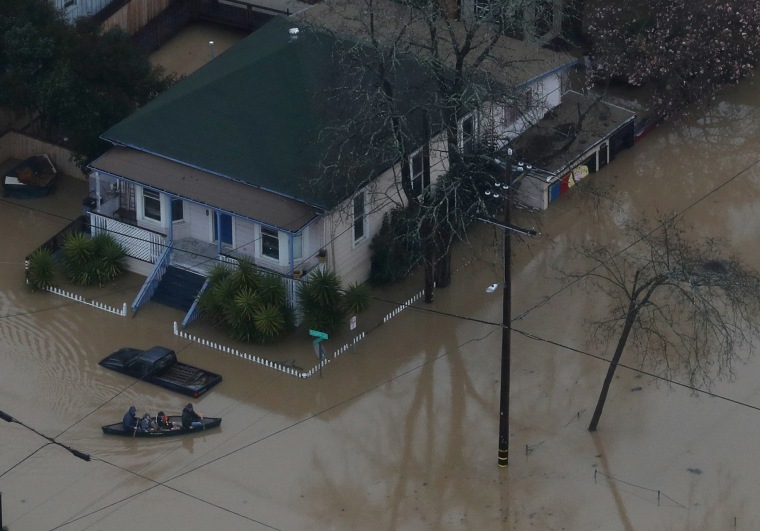 Image: People paddle a boat through a flooded neighborhood on Feb. 27, 2019 in Guerneville, California.