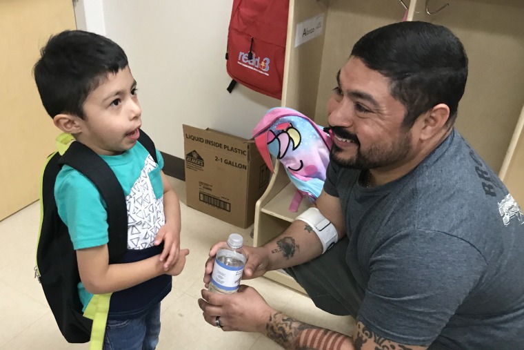 Enrique Martinez chats with his son Enrique, 4, as he picks him up at the Pre-K for SA South Education Center in San Antonio.