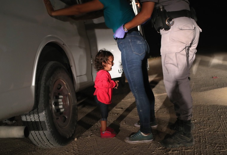 Image: A two-year-old Honduran asylum seeker cries as her mother is searched and detained near the U.S.-Mexico border