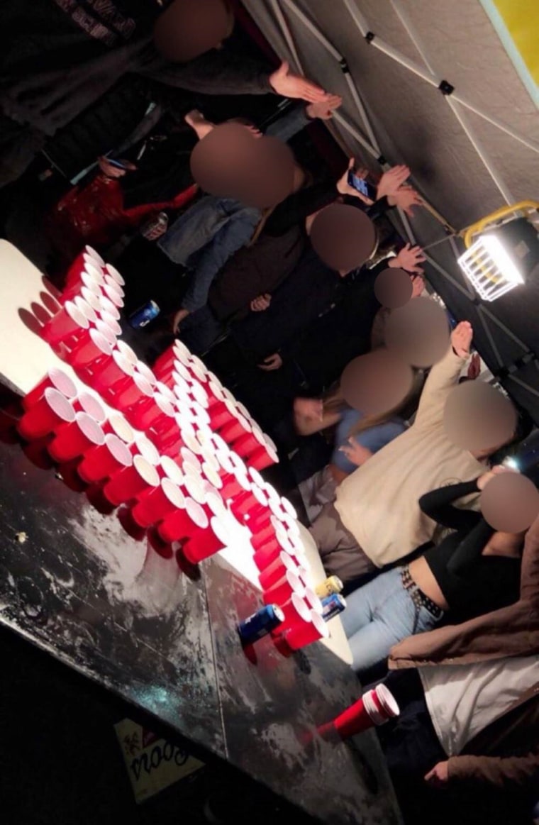 Image: Newport-Mesa students salute over a swastika made from red plastic cups. Faces obscured by NBC News.