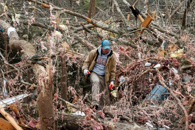 Image: Joey Roush walks through debris at his mother's home after it was destroyed by a tornado in Beauregard, Alabama, on March 4, 2019.