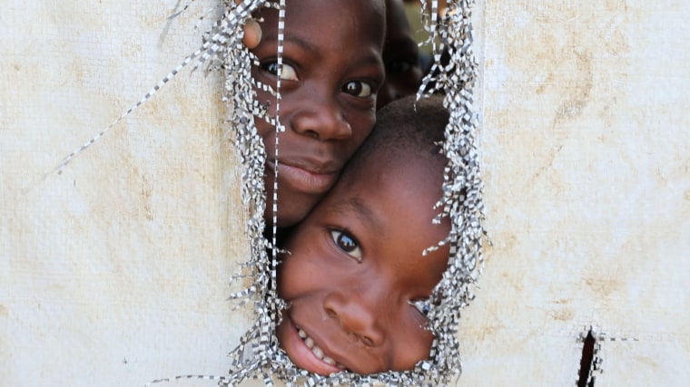 Image: Two children peek through a hole in a UN tent near Kaga-Bandoro, Central African Republic