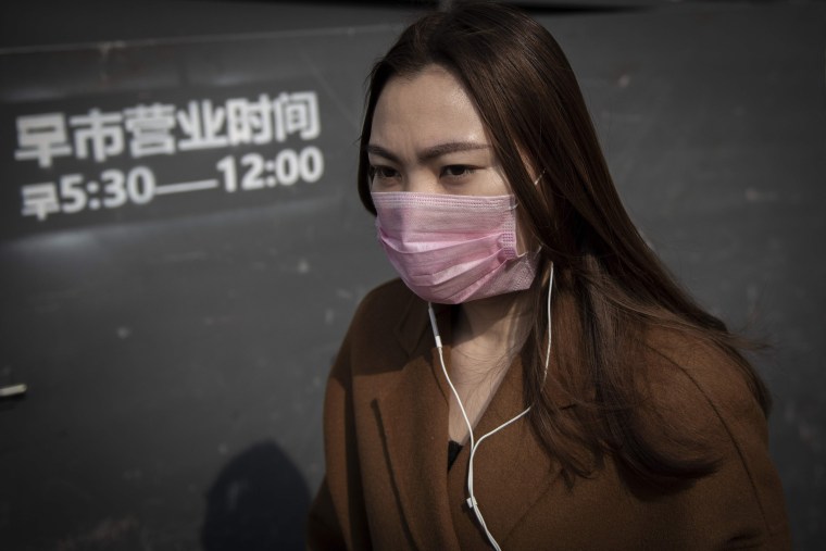 Image: A woman wears a mask to protect herself from the air pollution in Beijing