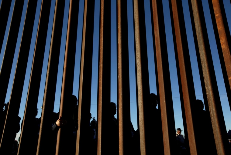 People gather on the U.S. side of the border fence between Mexico and the United States during an inter-religious service against President Trump's border wall, in Ciudad Juarez