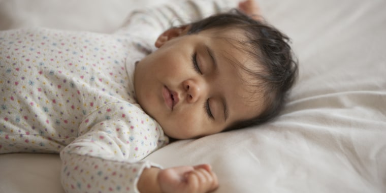 Mixed race baby girl sleeping on bed