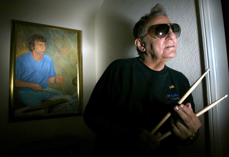 Image: Hal Blaine, one of the most famous drummers in the history of pop music, poses in front of an oil painting of himself in younger days
