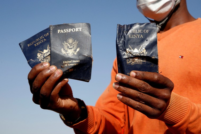 Image: Man holds passengers' passports found at the scene of the Ethiopian Airlines Flight ET 302 plane crash, near the town of Bishoftu, near Addis Ababa