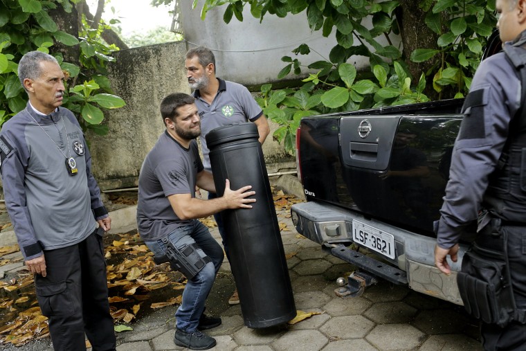 Image: A police officer carries evidence in the killing of Brazilian councilwoman Marielle Franco in Rio De Janeiro on March 12, 2019.