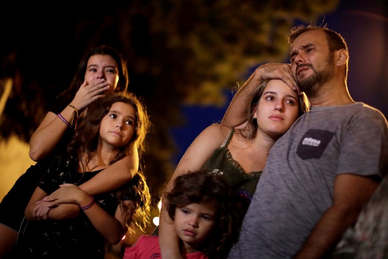 Image: Relatives, friends and students react as they pay tribute to victims of the shooting in Raul Brasil school in Suzano
