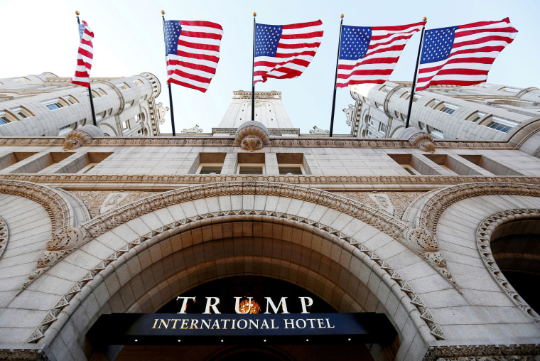 Image: Flags fly above the entrance to the new Trump International Hotel on its opening day in Washington