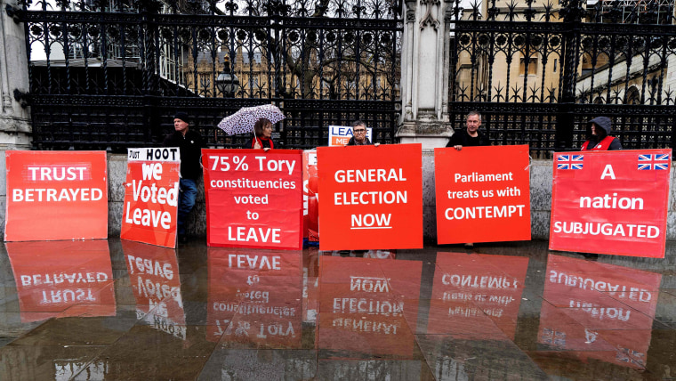 Image: Pro-Brexit activists hold placards as they demonstrate outside the Houses of Parliament in London