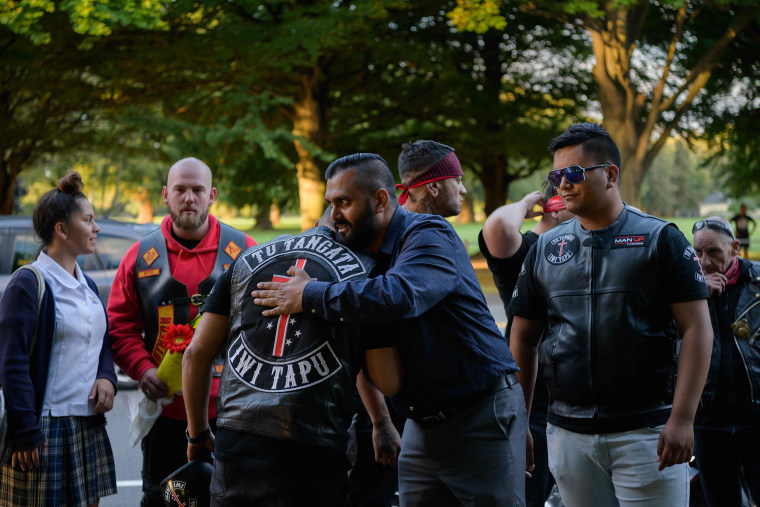 Image: Members of biker gangs arrive before performing the haka in front of a gathering of people as a tribute to victims in Christchurch
