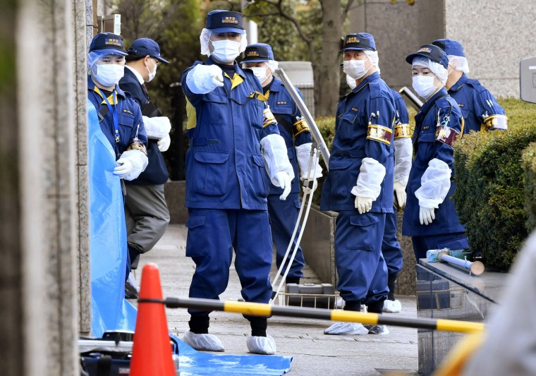 Image: Police investigate the scene after a woman was stabbed by her husband at a court in Tokyo on March 20, 2019.